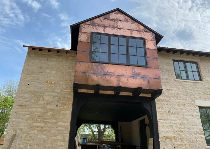 Copper metal panel facade on a stone building for Skylight Installation in Purcell