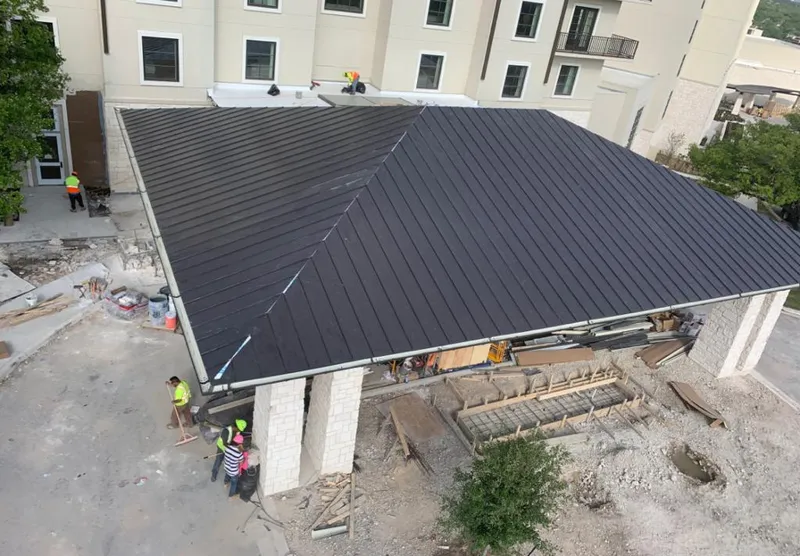 Metal roofing installation team working on a commercial building in Purcell